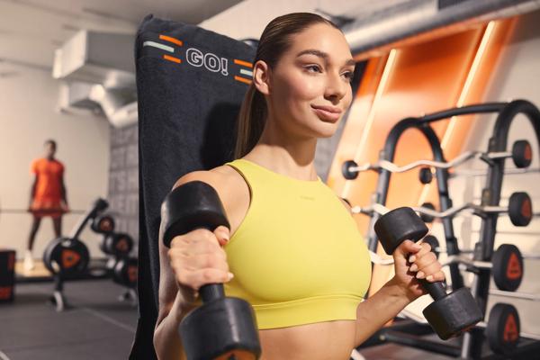 Femme s&rsquo;entra&icirc;nant avec des halt&egrave;res dans la zone Total Body Basics de Basic-Fit.