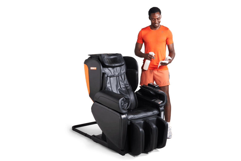 Man cleaning a massage chair at Basic-Fit.