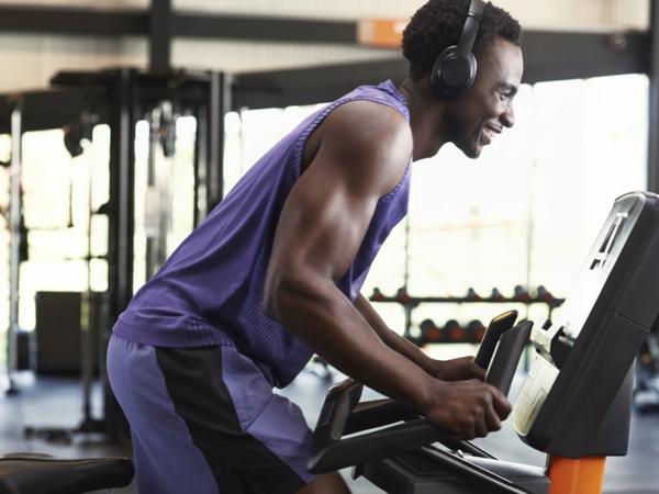 Homme s&rsquo;entra&icirc;nant sur un v&eacute;lo dans la zone Cardio Basics de Basic-Fit.