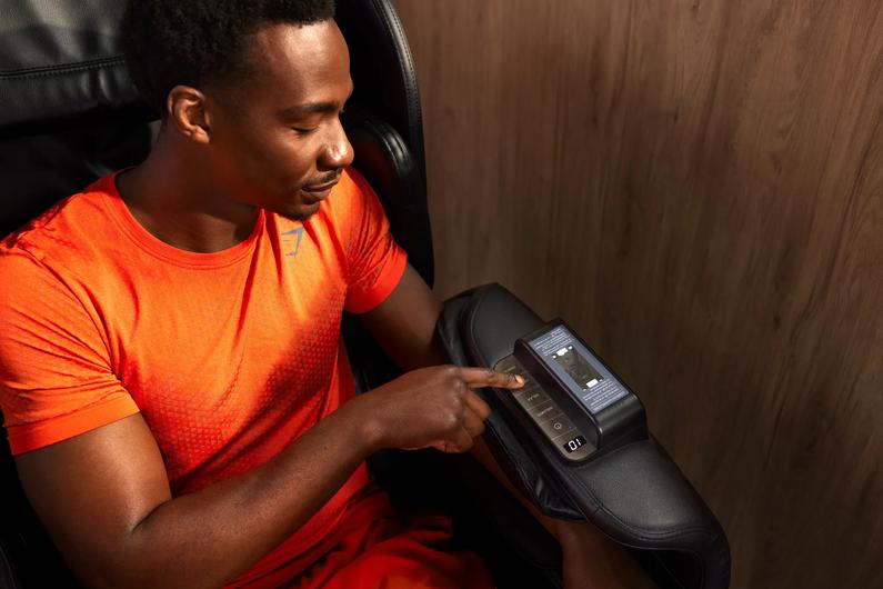 Man sitting in a massage chair at Basic-Fit.